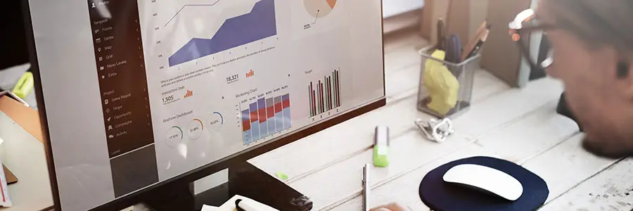 Person analyzing productivity data on a computer screen featuring charts and graphs, illustrating workplace analytics for enhanced team performance.