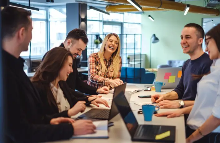 Managed IT Experts – Managed IT Services, Consulting, and Support for Businesses and Non Profits Group of professionals collaborating around a table with laptops, discussing managed IT services and technology solutions at E-Valve Technologies in a modern office setting.